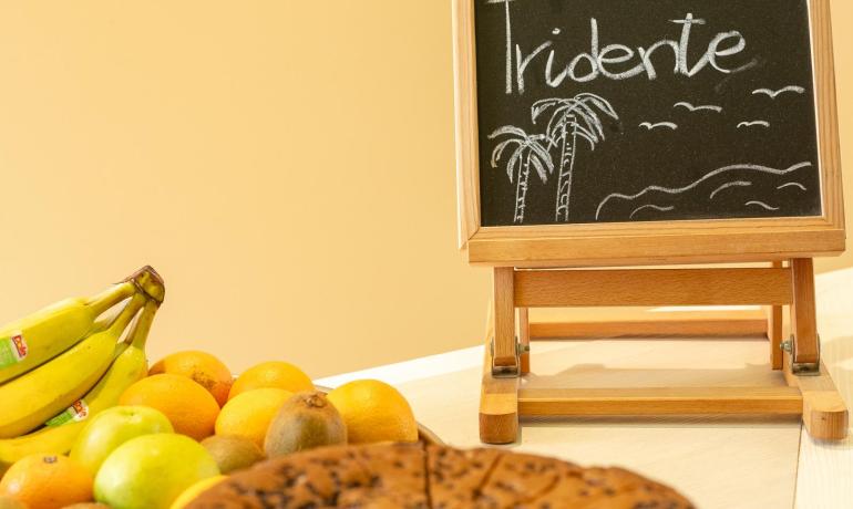 Einladender Tisch mit Kuchen und Obst, Tafel mit herzlicher Botschaft.