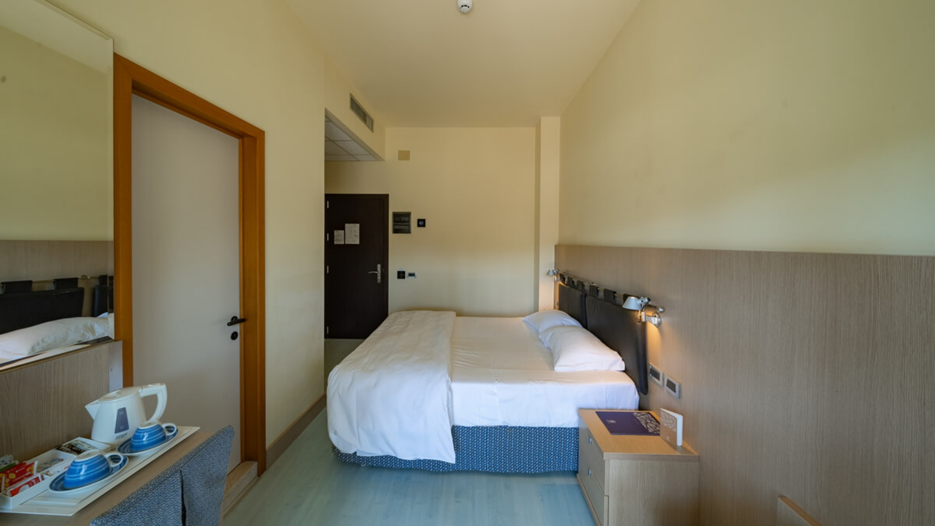 Modernes Hotelzimmer mit Doppelbett und Wasserkocher.