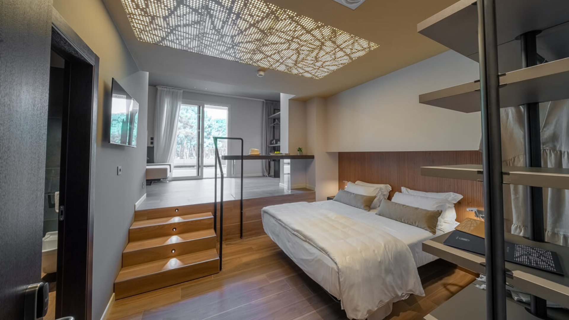 Modern room with bed, mezzanine, and decorative lighting.