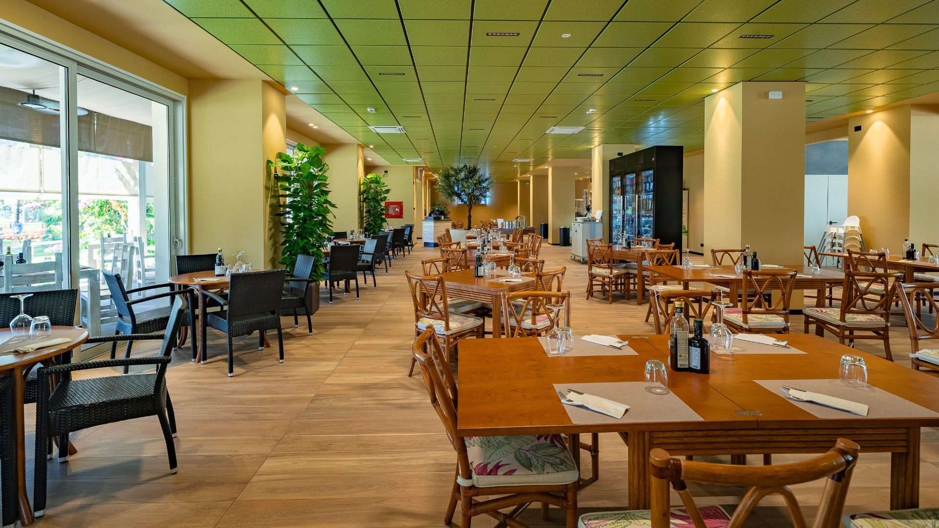 Ristorante elegante con tavoli in legno e sedie intrecciate, atmosfera accogliente.