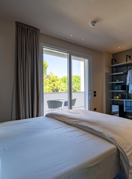 Modern room with balcony, double bed, and desk.