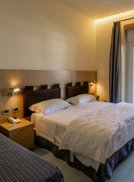 Bright hotel room with double bed and terrace.