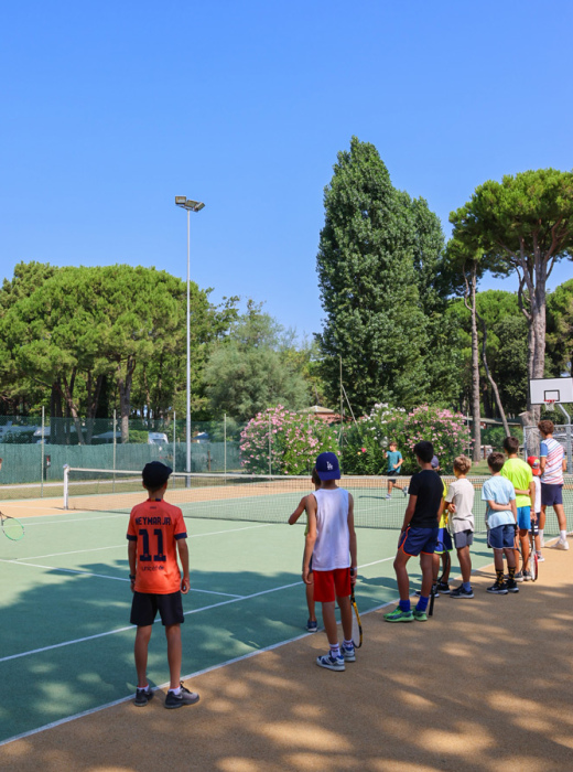 Bambini giocano sulla spiaggia con un'animatrice, giornata di sole e divertimento.