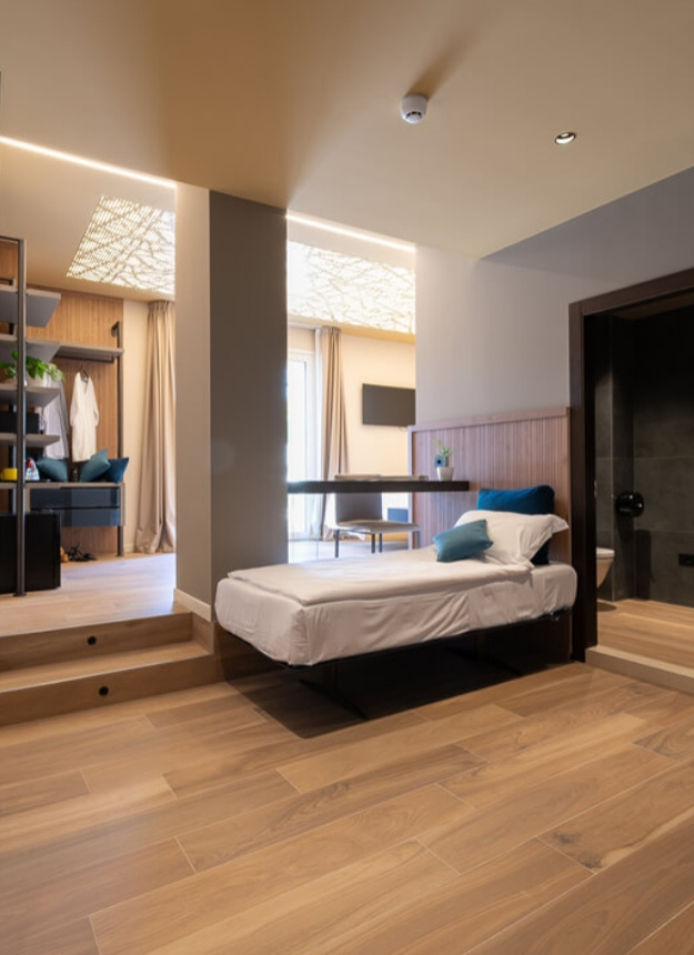 Modernes Zimmer mit Einzelbett, Holzboden und privatem Bad.
