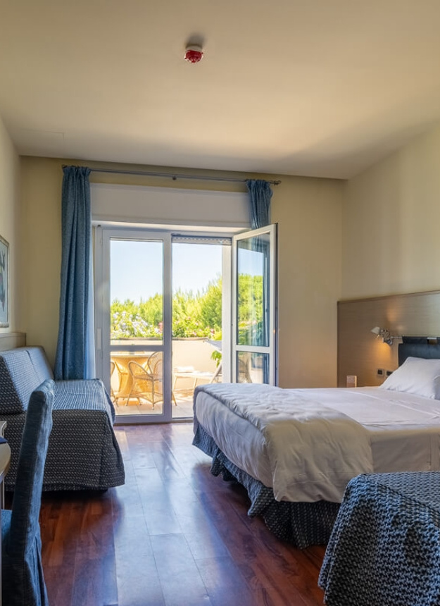Bright room with balcony, double bed, and modern furnishings.